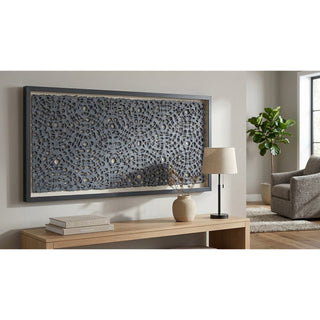 Living room with a large decorative wall piece, lamp, and books on a wooden console table.